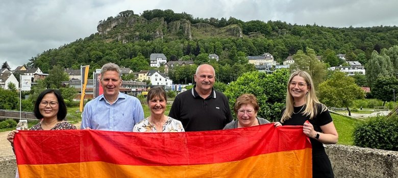 Gerolstein lässt die bunten Fahnen wehen. Tukta Schwarz, ForumEineWelt e.V., Bürgermeister Hans Peter Böffgen, Gleichstellungsbeauftragte Gudrun Nahrendorf, Gotthard Lenzen, Ortsvorsteher Gerolstein-Roth, Christa Karoli, ForumEineWelt e.V., und Lena Werner, MdB (v.l.) setzen ein Zeichen gegen Intoleranz und Ausgrenzung.